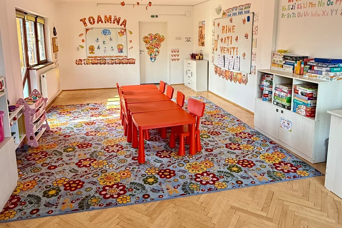Sala decorată de toamnă, cu masă mare și indicatorul cu regulile grupei